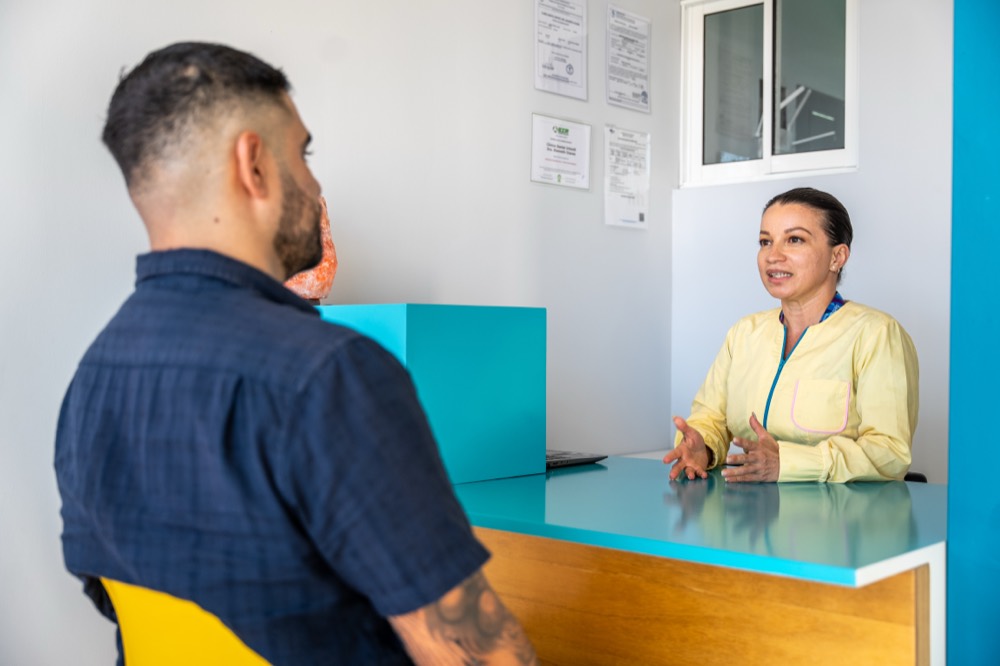 Recepción de la clínica atendiendo a un papá